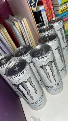 four cans of energy drink sitting on top of a shelf