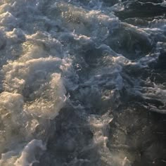 the water is choppy and foamy as it moves through the ocean waves on a sunny day