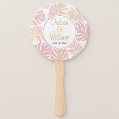 a pink and gold palm leaf fan with the name chelsea and william printed on it