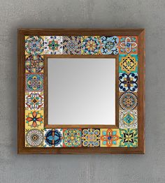 a mirror that is on the wall with some tile around it and a wooden frame