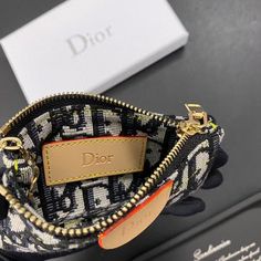 the dior coin purse is on display in front of a black and white box