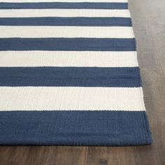 a blue and white striped rug sitting on top of a wooden floor