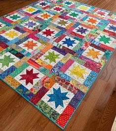 a multicolored patchwork quilt on the floor