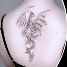 a woman's back with a dragon and roses tattoo on her upper back shoulder