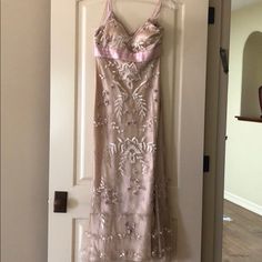 a pink dress hanging on a door in front of a white door with a mirror