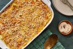 a casserole dish with almonds and parmesan cheese in it on a table