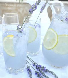 lavender water and lemonade are served in pitchers on a white tablecloth with lavender sprigs