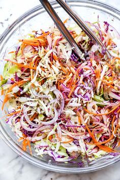 a glass bowl filled with coleslaw and carrots