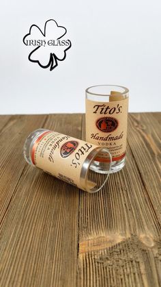 an empty shot glass sitting on top of a wooden table next to a cork holder