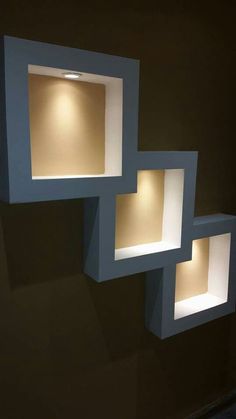 three square lights are lit up on the wall