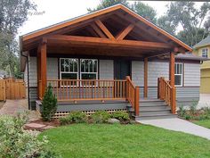 a small gray house with wooden porches