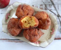 doughnut holes on a plate with an apple in the background