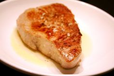 a piece of meat sitting on top of a white plate