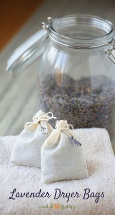 lavender drier bags are sitting on a towel next to a glass jar filled with lavenders