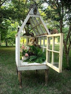 an old window is transformed into a garden house