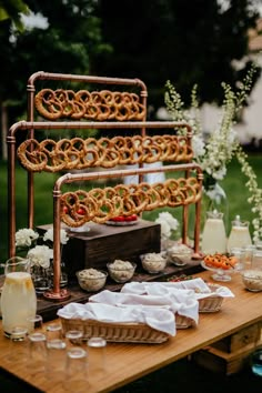 a table topped with pretzels and other food on top of a wooden table