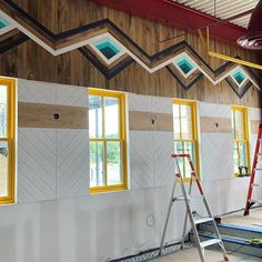 an unfinished room with several windows and ladders