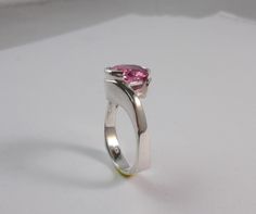 You are looking at a beautiful simulated 10x8 mm oval pink tourmaling. Set in a original contemporary designer ring in sterling silver. The ring features a square European shank which adds weight to the bottom of the ring to help it stay upright. It also adds style and innovation. Comes in sizes from 5 to 8. I am Ernesto an award winning designer, I manufactur all my jewelry. Allow 5 days shipping after order. 7 day money back return. Modern Pink Jewelry With Polished Finish, Modern Pink Ring For Formal Occasions, Modern Pink Rings For Formal Occasions, Modern Pink Gemstone Rings, Modern Pink Ring For Anniversary, Modern Pink Rings For Wedding, Modern Pink Jewelry For Anniversary, Modern Pink Promise Ring, Modern Pink Rings With Polished Finish