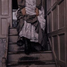 a woman is standing on the stairs in a dress