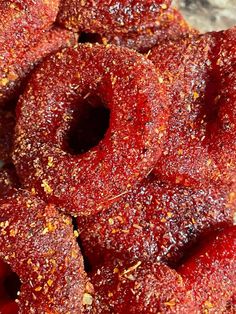 some red food that is sitting on a white plate with sprinkles and seasoning