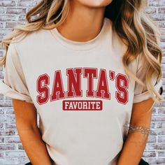 Be Santa's Favorite this year! This Christmas shirt is perfect for spreading holiday cheer and celebrating the festive season. Made from soft and durable ring-spun cotton, this unisex t-shirt offers a comfortable fit and versatile style. It is ideal for anyone looking to add a touch of Christmas spirit to their wardrobe or to give as a thoughtful gift during the holidays. Adult shirts are a soft Gildan Softstyle Shirt.  Youth shirts are 100% cotton.  Design is hand pressed using high quality DTF Transfers. Letters Christmas, Varsity Letters, Varsity Letter, Holiday Shirt, Adulting Shirts, Holiday Shirts, Festive Holiday, Dtf Transfers, Festive Season