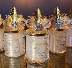 four glass jars with gold leaf decorations on the top and bottom, all lined up in rows