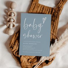 a baby shower card sitting on top of a bed