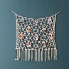 a macrame with pictures hanging on it and string attached to the wall, in front of a blue background