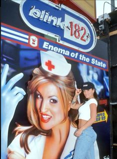 a woman is standing in front of a billboard