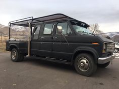 a black truck parked in a parking lot with mountains in the backgrouund