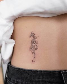 a woman's stomach with a flower tattoo on it