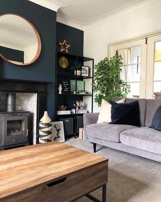 a living room filled with furniture and a wood burning stove in the middle of it