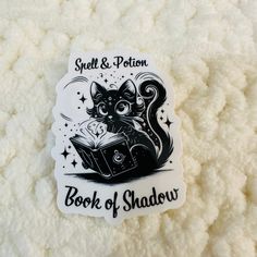 a black and white sticker with an image of a cat reading a book on it