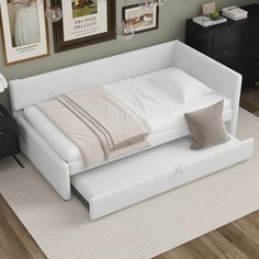 a white bed sitting on top of a wooden floor