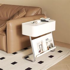 a white table with magazines on it next to a couch