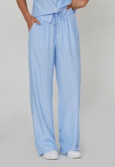 är en klassisk blå- och vitrandig byxa med vida ben och fickor i sidan. Byxorna har hög elastisk midja med dragsko. Modellen är 175 cm lång och har storlek S. Classic Straight Pants For Loungewear, Classic Loungewear Trousers, Classic Full Length Loungewear Pants, Classic Full-length Loungewear Pants, Classic Daywear Bottoms With Pockets, Classic Wide-leg Pants For Loungewear, Classic Wide-leg Loungewear Pants, Elegant Blue Wide Leg Pants With Elastic Waistband, Elegant Light Blue Trousers