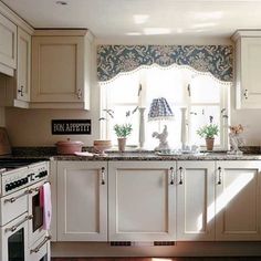 a kitchen with an oven, sink and stove in it's center island next to a window