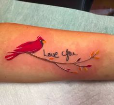 a red bird sitting on top of a branch with the words love you