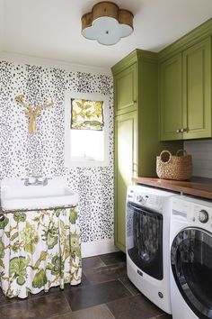 a washer and dryer in a small room with wallpaper on the walls