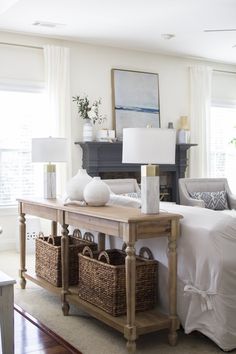 a living room filled with furniture and baskets on top of a table in front of a window