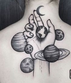 the back of a woman's neck with an image of planets and hands on it