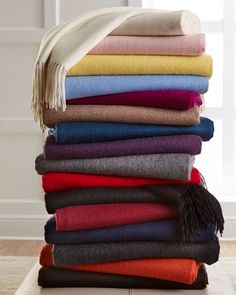 a stack of folded towels and blankets on the floor