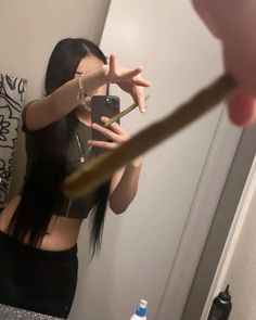 a woman taking a selfie in front of a bathroom mirror with a toothbrush