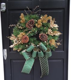 a wreath with pine cones and evergreens on the front door