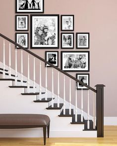 a staircase with pictures on the wall and a bench under it in front of some stairs