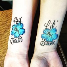 two blue flowers on both wrist tattoos that say big sister and little sister