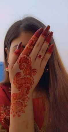 a woman with her hands on her face covered in hendike, covering her eyes