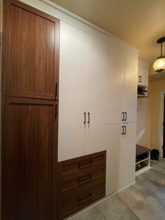 an empty room with white cabinets and brown drawers on the wall next to a doorway