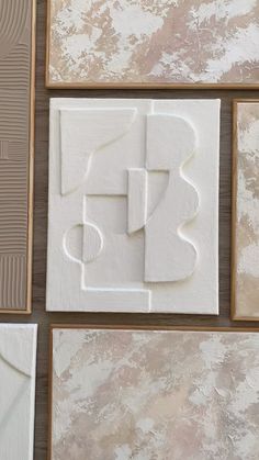 some white and brown tiles are arranged on the wall with different shapes, sizes and colors