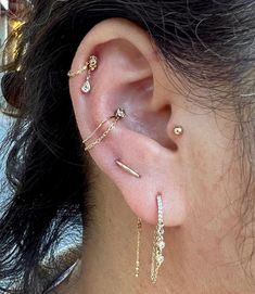 a close up of a person's ear with three different types of piercings